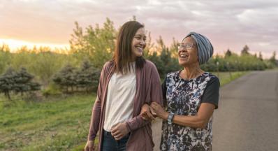 Two women walking speaking about COVID 19